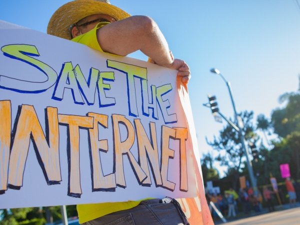 Man holding sign reading "Save the internet"