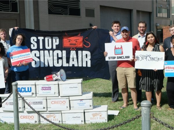 Activists with boxes of petitions and "Stop Sinclair" sign