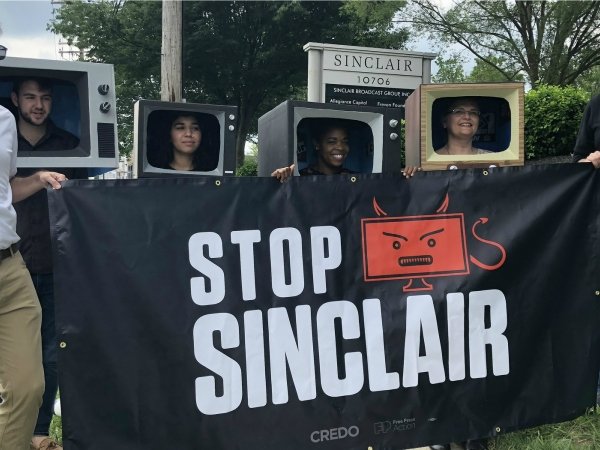 Activists holding "Stop Sinclair" banner