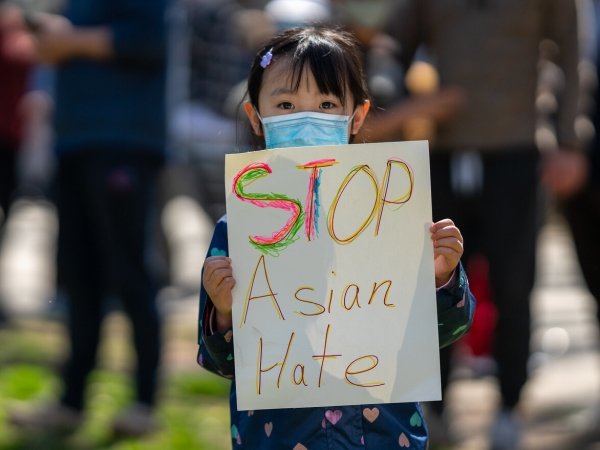 Girl holding a poster reading "Stop Asian hate"