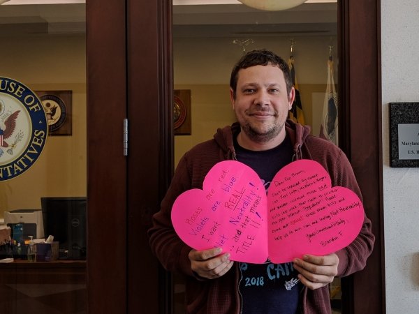 Net Neutrality activist holds a valentine outside Rep. Brown's office.