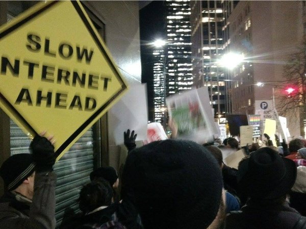Protester holding sign reading "Slow internet ahead"