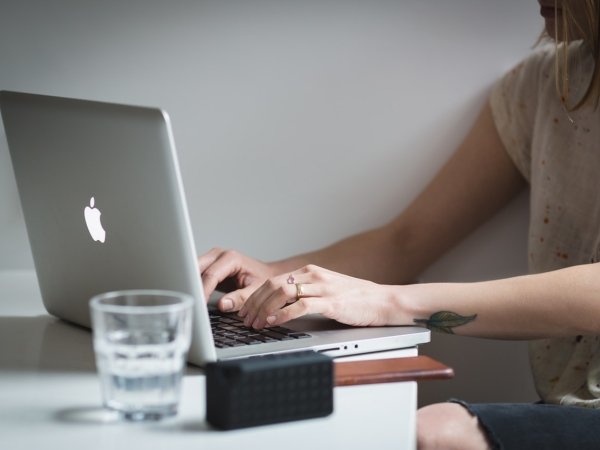 Woman typing on a Macbook