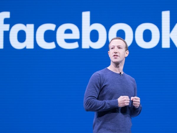 Mark Zuckerberg against a blue screen reading "Facebook"