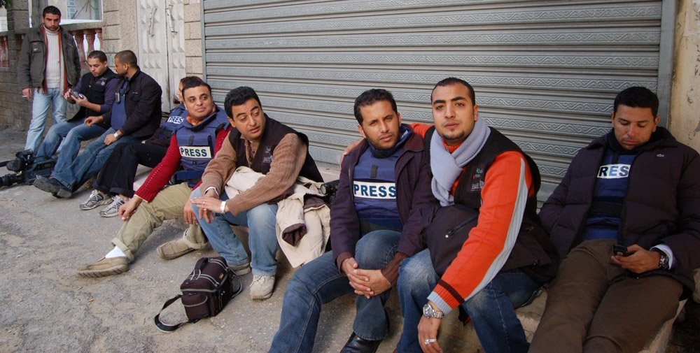Journalists in Gaza sitting on the ground