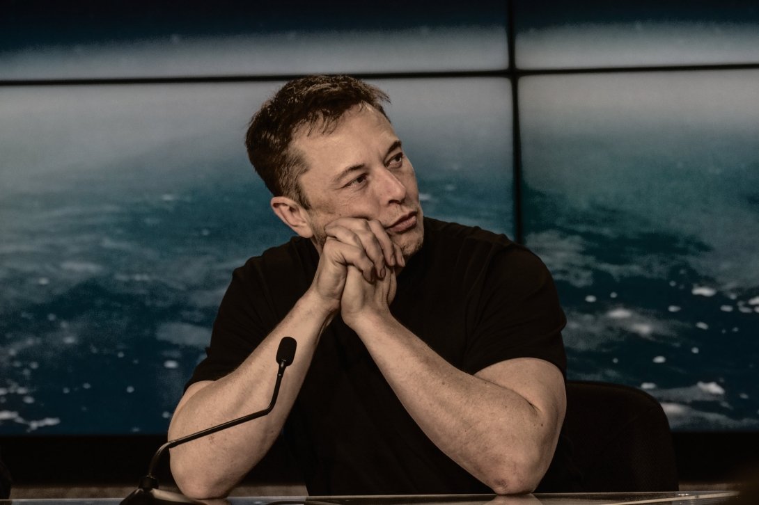 Elon Musk sitting at a table