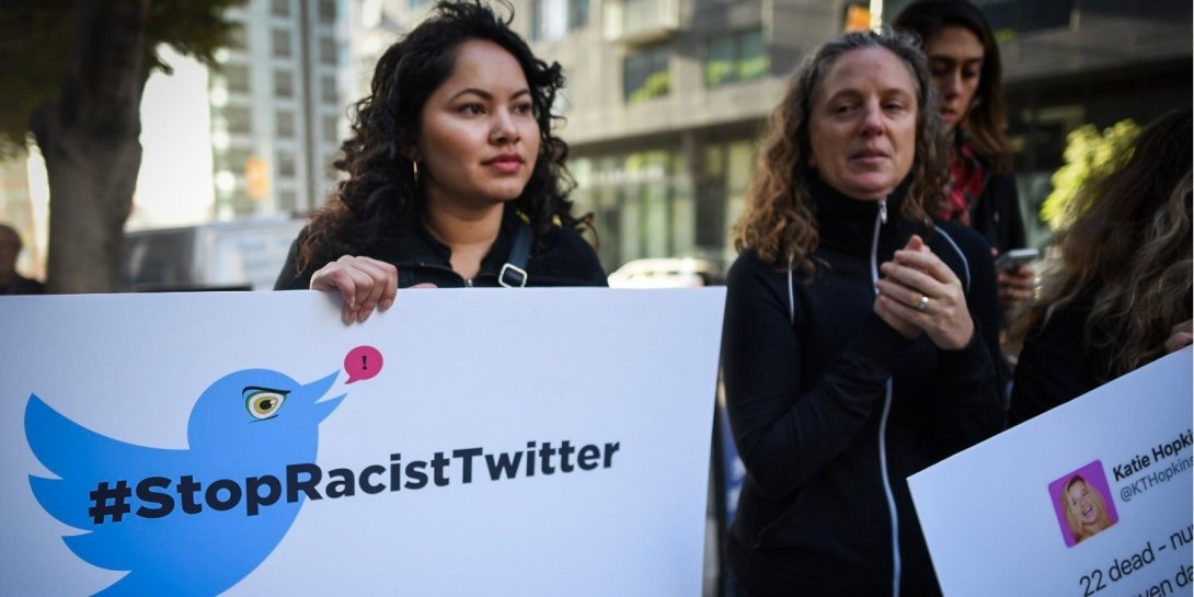 Protesters outside Twitter headquarters holding signs reading "Stop Racist Twitter"