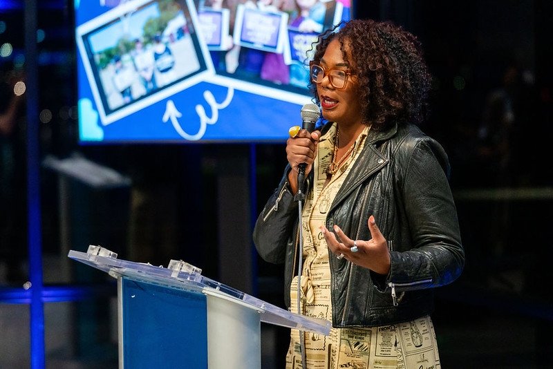Free Press board member and longtime ally Brandi Collins-Dexter speaking into a microphone at Free Press' 20th-anniversary party