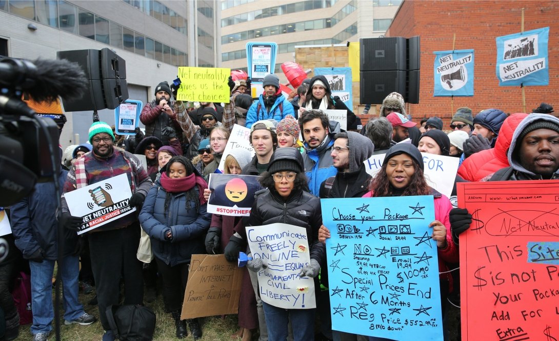 Dozens of Net Neutrality activists holding signs