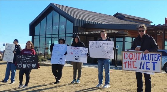 Oklahoma protesters holding signs reading "Don't neuter the net" and "Killing Net Neutrality kills free speech"