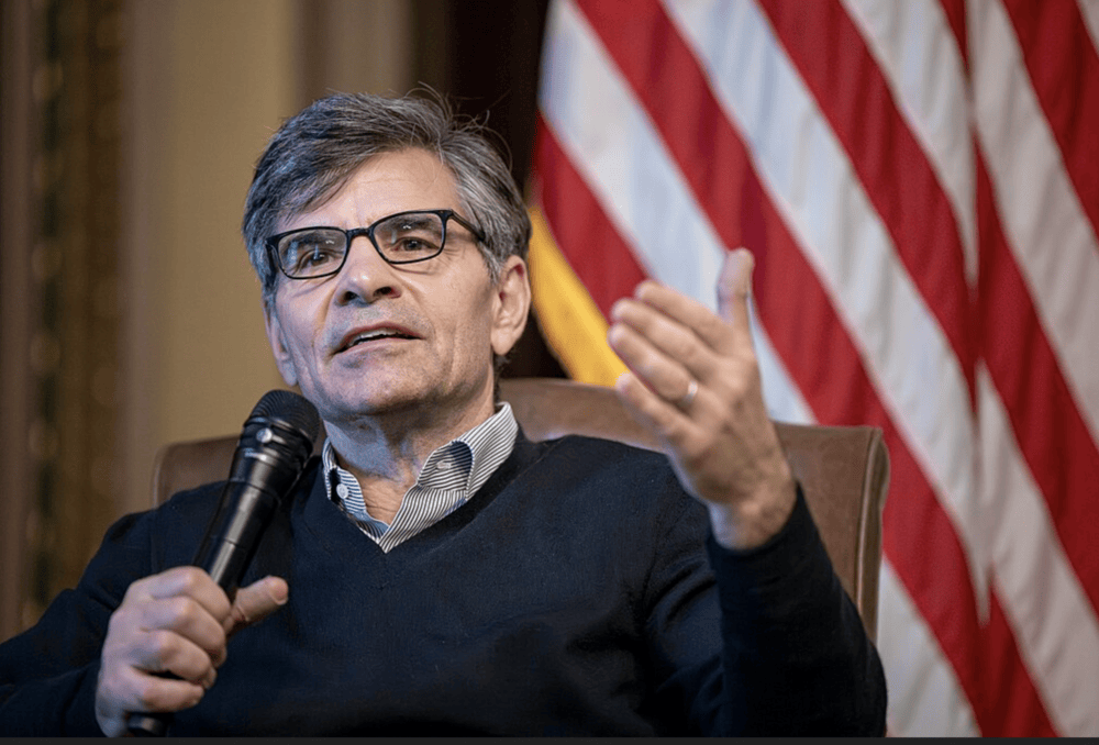 George Stephanopoulos holding a microphone