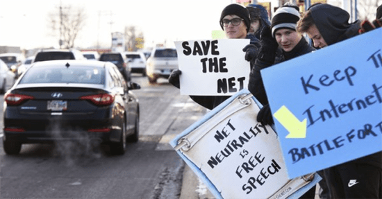 South Dakota protesters holding "Save the Net" and "Net Neutrality is free speech" signs