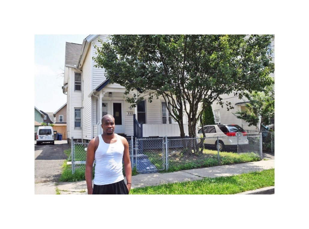 Aaron Tucker standing in front of a house