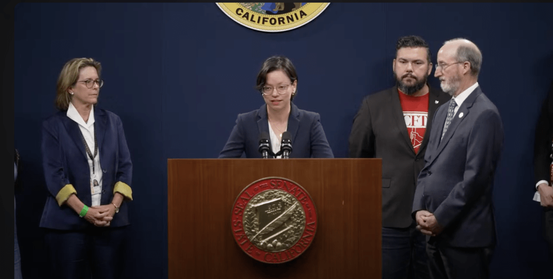 Free Press Action's Qing Saville at podium delivering remarks about a California local journalism bill 