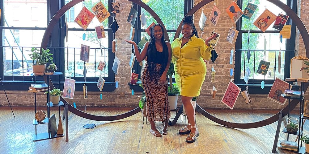 Diamond Hardiman and Venneikia Williams in front of the Black Future Newsstand exhibit, which explores Black liberation