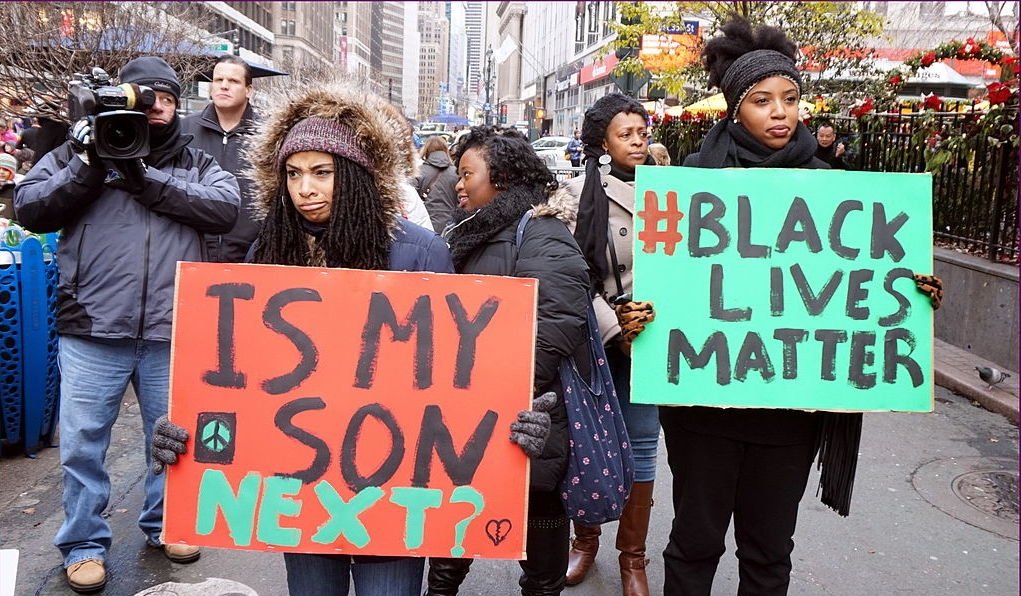 Women holding posters at a Black Lives Matter protest