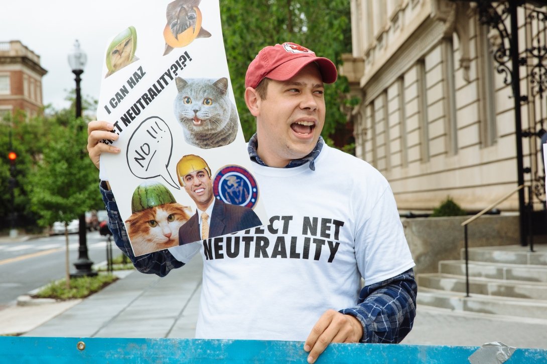 Activist holding sign reading "I can haz Net Neutrality?!?!"