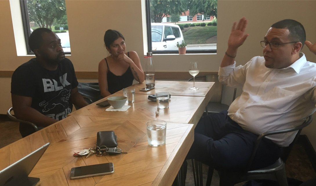 Residents and reporters talking at a table