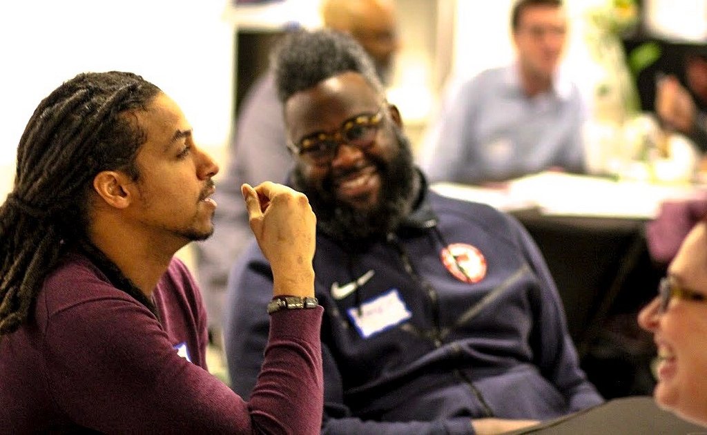 Three people talking at a table during the Charlotte event