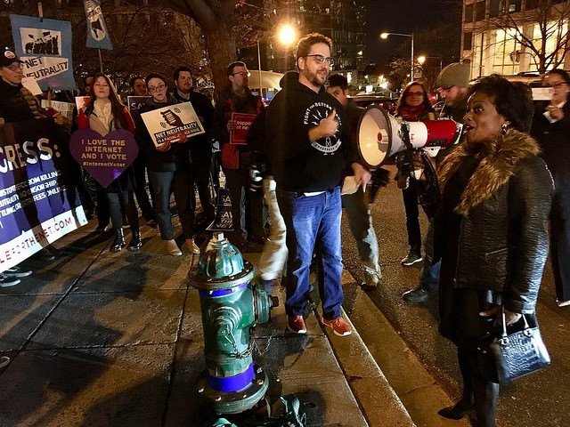 FCC Commissioner Mignon Clyburn speaking into megaphone in front of activists