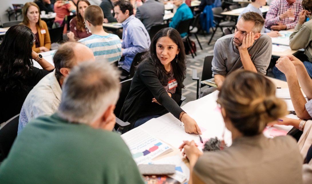 People talking around a table at the local-news gathering.