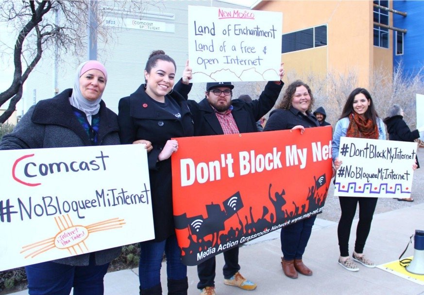 Activists holding signs reading "Don't block my net" in English and Spanish