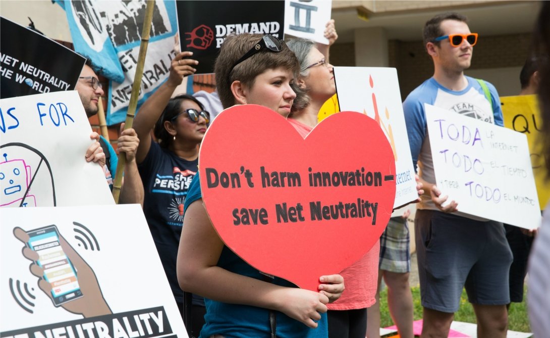 Net Neutrality rally featuring woman holding sign reading "Don't harm innovation / save Net Neutrality"