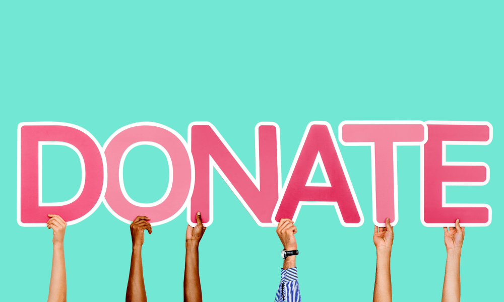 Hands holding up the word "Donate"