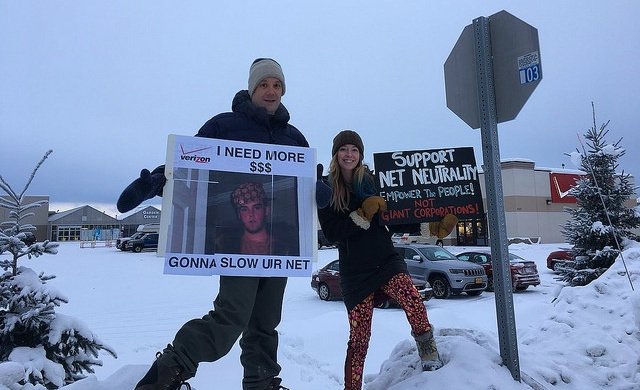 Two Fairbanks protesters in snow holding signs reading "Support Net Neutrality"