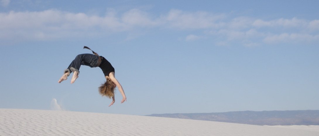 Woman doing back handspring on a beach