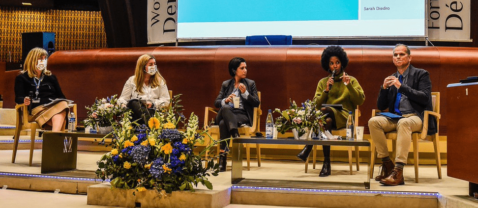 Five panelists on stage at the World Forum for Democracy