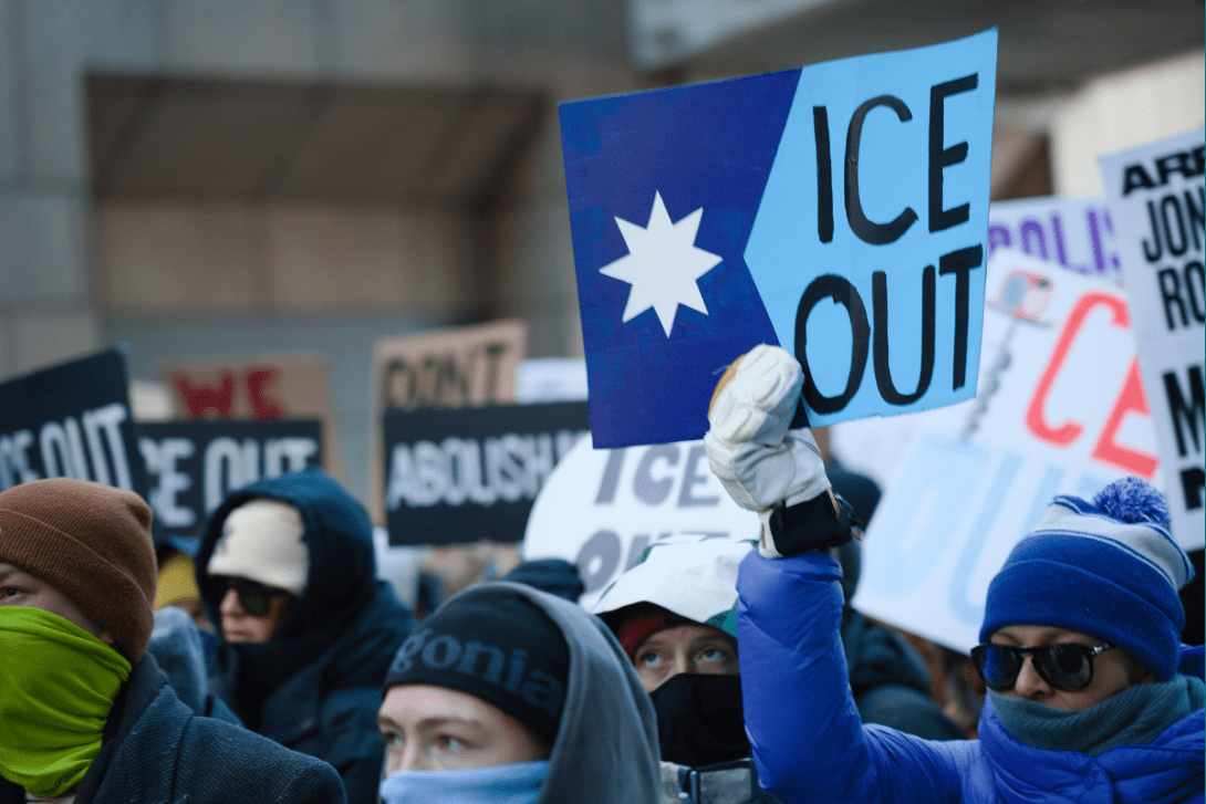 Protesters holding signs reading "ICE Out"