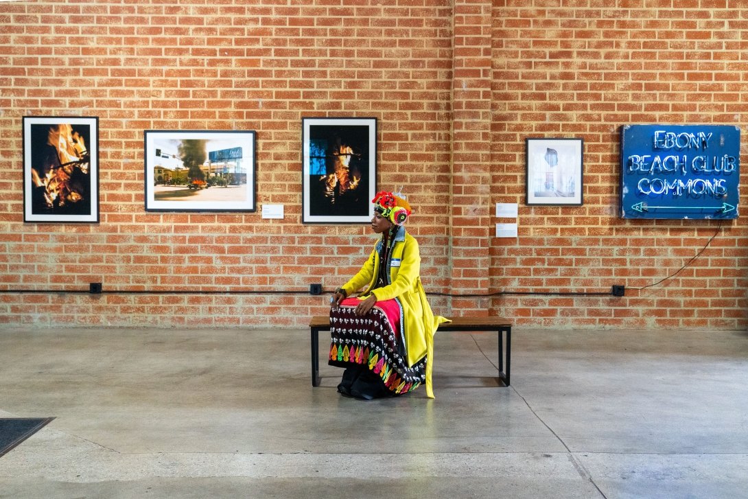 A visitor looking at art in the Black Future Newsstand exhibit in Los Angeles