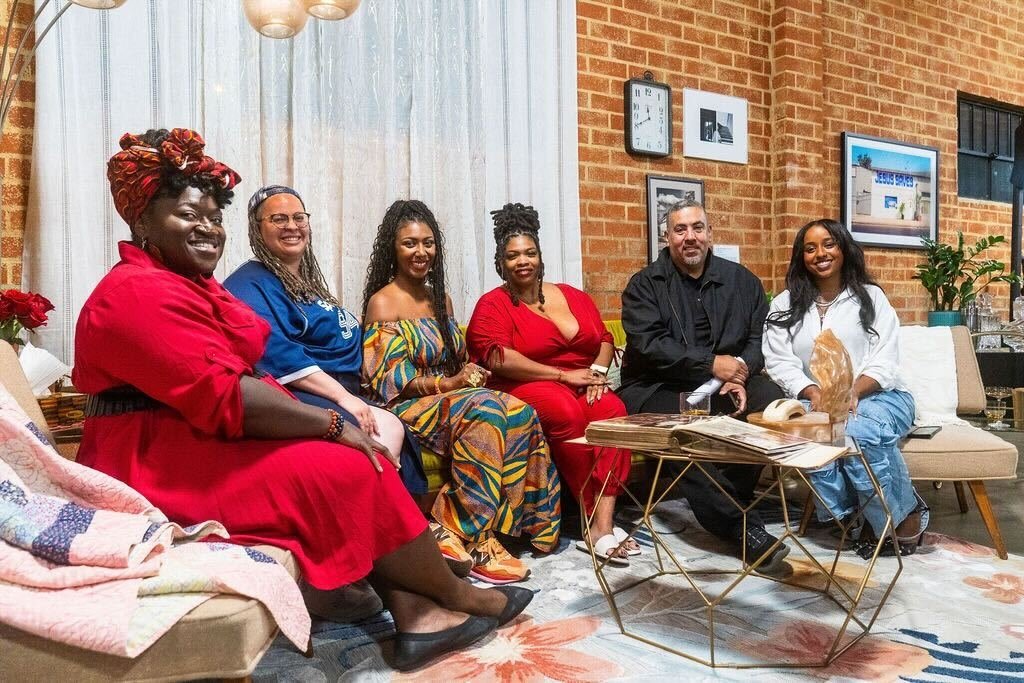 Members of the Media 2070 team sit on a couch at the Black Future Newsstand exhibit in Los Angeles