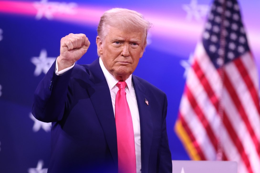 Trump holding a fist up at the 2025 Conservative Political Action Conference