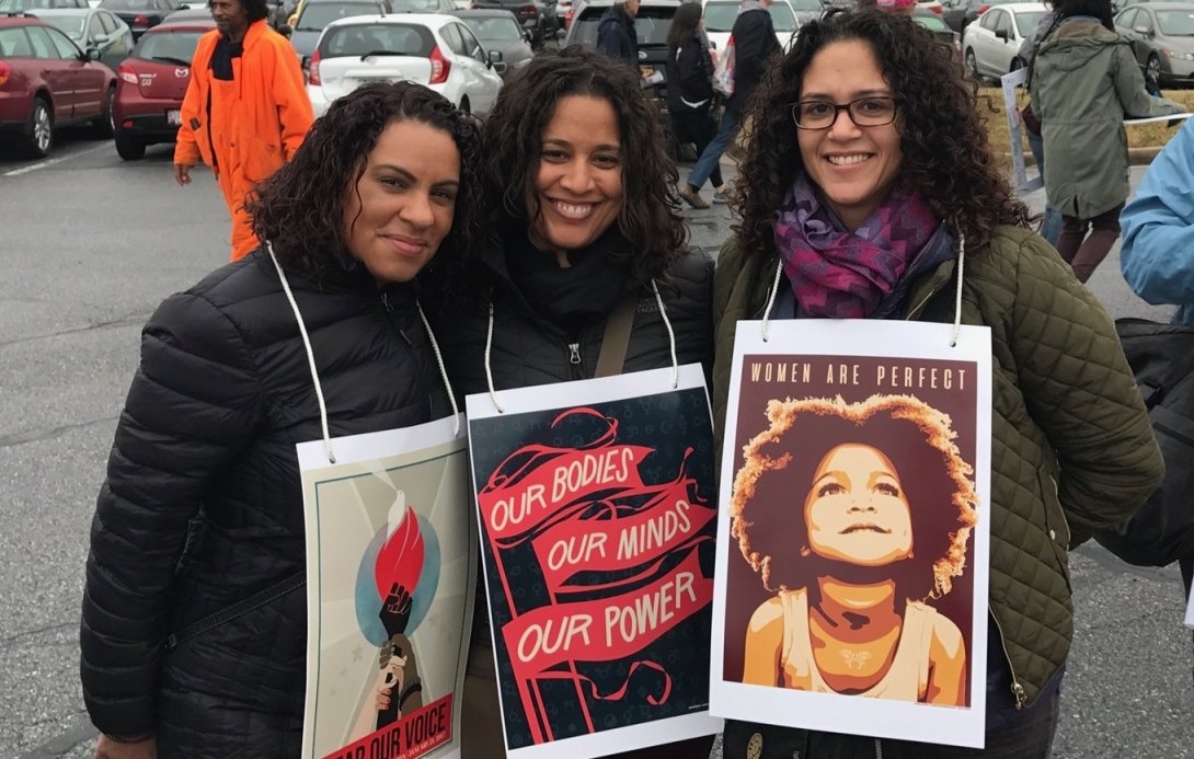 The author with two friends holding Women's March posters