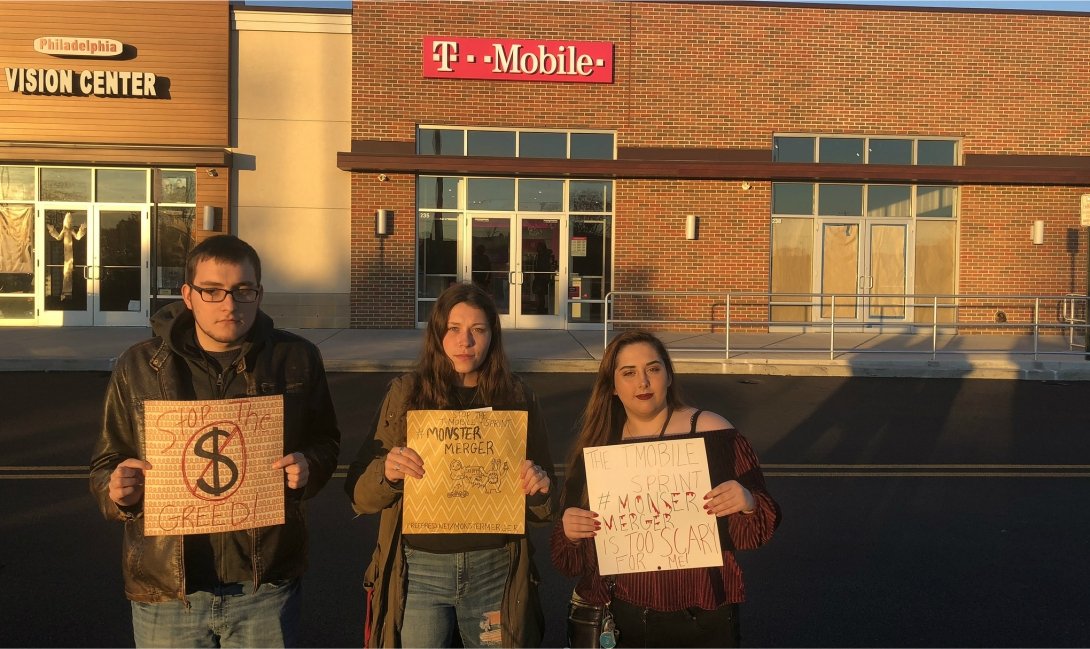 Three activists protesting the T-Mobile/Sprint merger