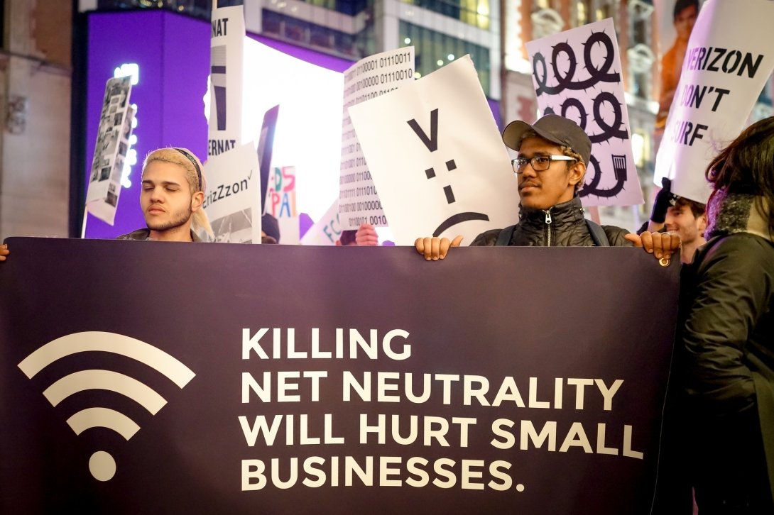 Activists holding sign reading "Killing Net Neutrality will hurt small businesses"