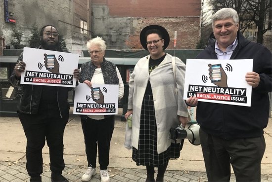 Protesters holding "Net Neutrality is a racial justice issue" signs