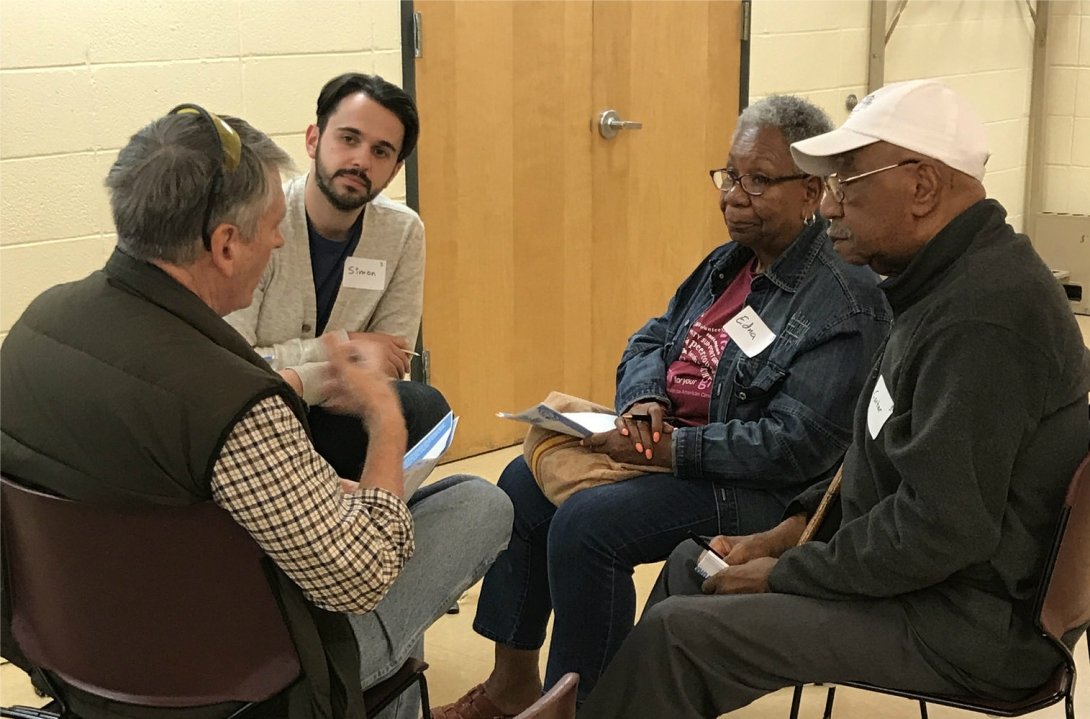 Four people talking while seated close together