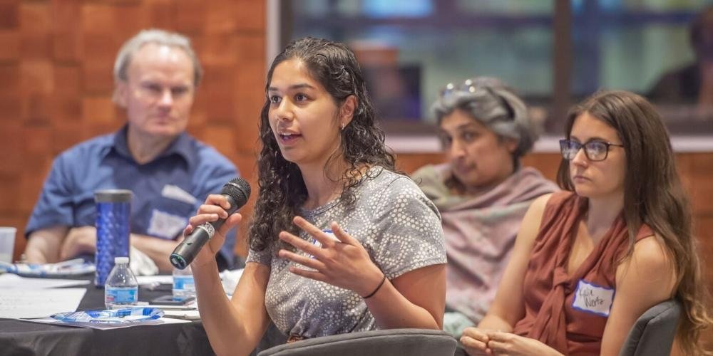 Attendee speaking into a microphone at an Organizing for Neighorhood News event.