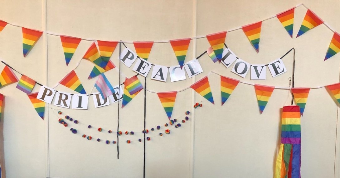 Rainbow flags with the signs "Pride," "Peace" and "Love"