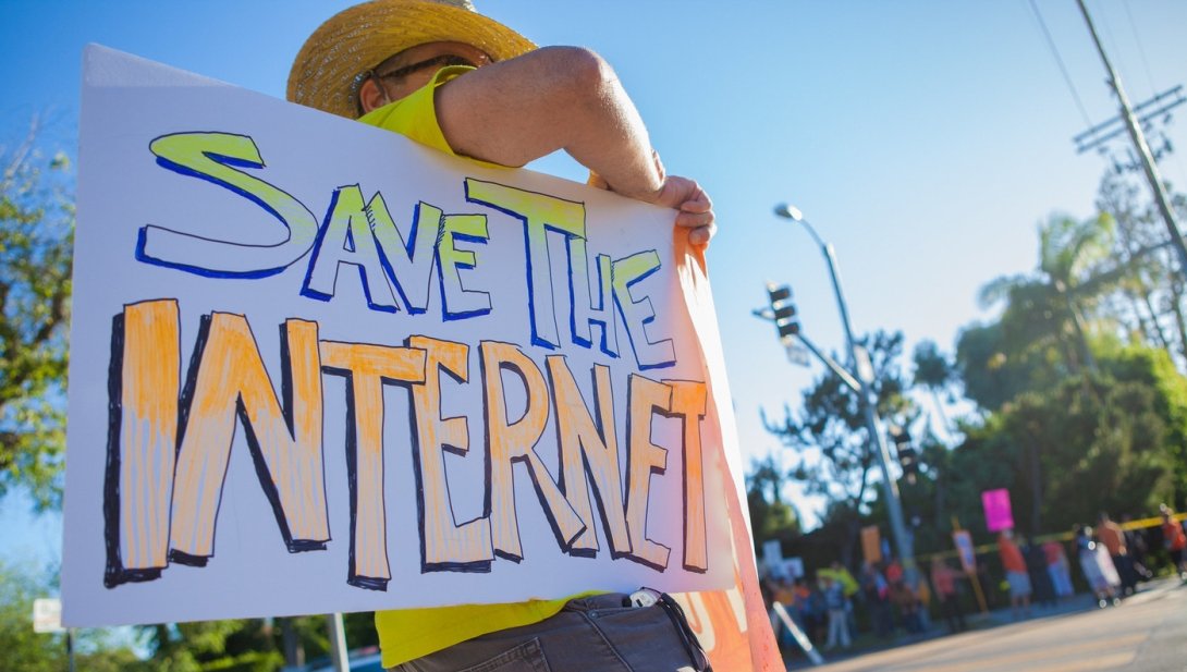 Man holding sign reading "Save the internet"