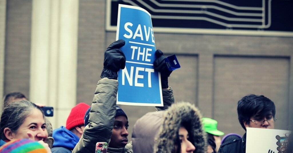 Activist holding a sign reading "Save the Net"