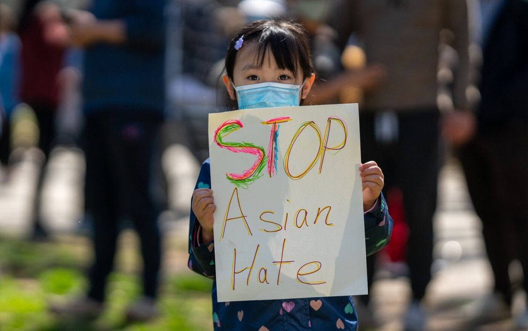 Girl holding a poster reading "Stop Asian hate"