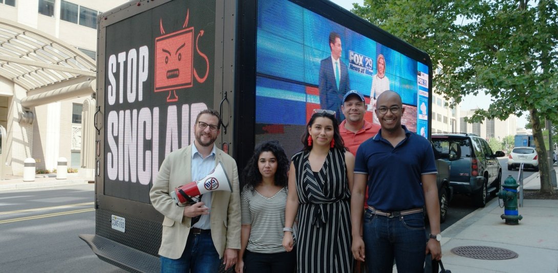 Free Press staffers in front of a truck reading "Stop Sinclair"