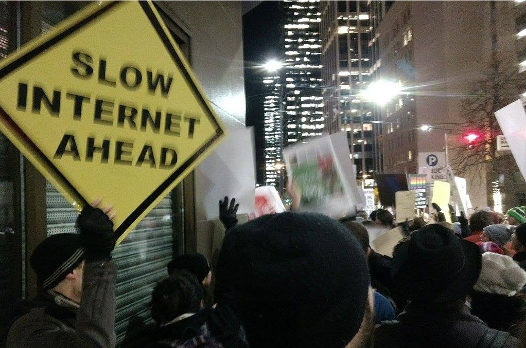 Protester holding sign reading "Slow internet ahead"